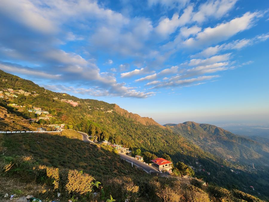 Top 10 Places to visit in India in Summer With Family in 2024 4 Resplednant views of the white clouds in azure sky above the rolling tea gardens and Himalayan houses