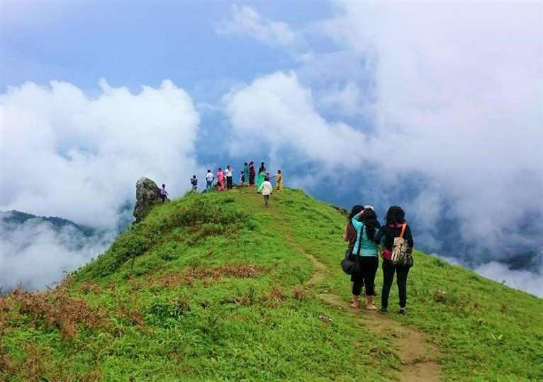 Me and my friends at the Tadiadmol Peak with the clouds at nose level. Such views make Coorg one of the best hill stations near Bangalore for weekend trips