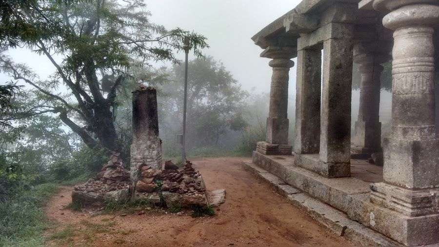 An old temple perched on a hill, enveloped in morning mist, evoking a serene and mystical atmosphere