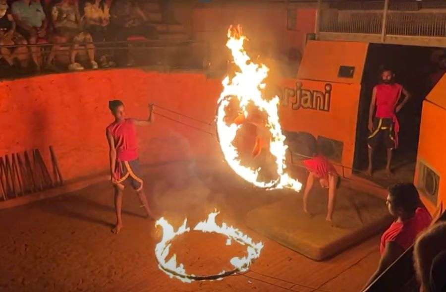 Artists jumping into the fire rings while performing Kalaripayattu , an ancient martial art form in Kerala