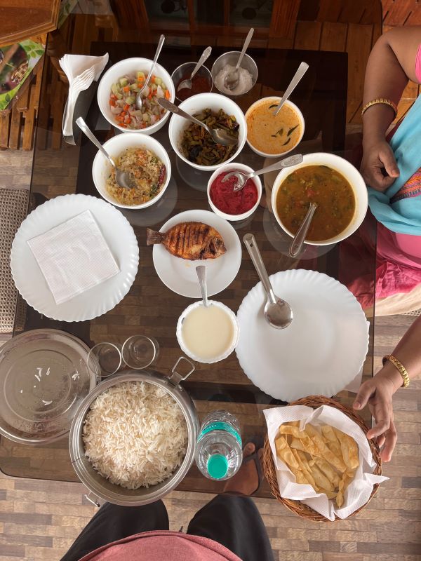 A table full of Keralite delicacies - rice, fish, curry, dal, vegetables, fruits , dessert